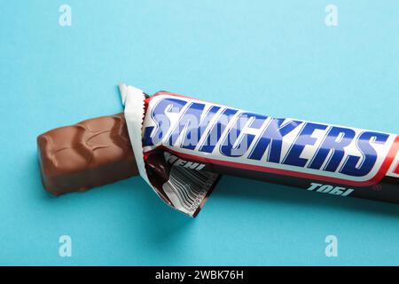 Nikolaev, Ukraine - 19. Dezember 2021 Snickers Schokoladenriegel auf blauem Hintergrund. Snickers ist ein Schokoladenriegel der amerikanischen Firma M Stockfoto