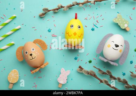 Osterferienkonzept mit niedlichen handgemachten Eiern, Hunden, Küken und Katzen auf minzfarbigem Hintergrund. Draufsicht. Frohe Ostern Stockfoto