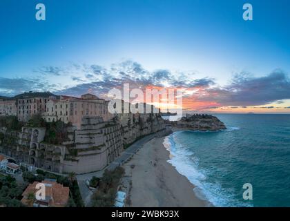 Tropea, Italien - 16. Dezember 2023: Panoramablick auf den Strand von Rotonda und die farbenfrohe Altstadt von Tropea in Kalabrien bei Sonnenuntergang Stockfoto