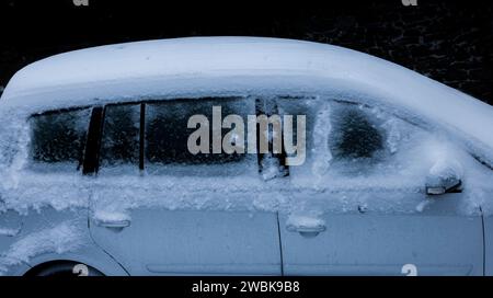 Schneebedecktes Auto mit viel Neuschnee im Winter Stockfoto