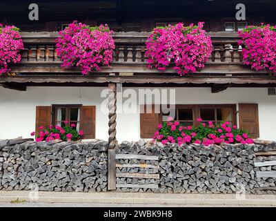 Holz vor einem Bauernhaus mit Blumenschmuck Stockfoto