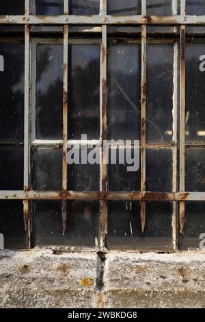 Rostiges Metallgitter vor einem alten Schiebereisen-Fenster Stockfoto