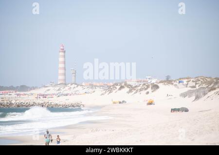 Der Strand von Costa Nova do Prado bei Aveiro und der Leuchtturm von Praia da Barra an der Atlantico Küste Portugals Stockfoto