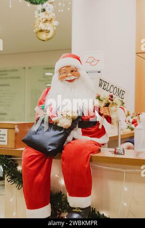 Santa Claus Statuen sitzen auf der Bank Stockfoto