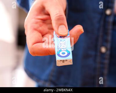 Tambow, Russische Föderation - 20. Dezember 2023 Eine Frau, die eine Packung Kaugummi aus Wrigley's Orbit gibt. Stockfoto