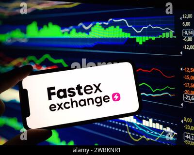 Konskie, Polen - 05. Januar 2024: Das Logo der Fastex-Kryptowährung wird auf dem Smartphone auf dem Hintergrund von Kryptomarktdaten angezeigt Stockfoto