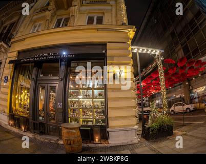 BELGRAD, SERBIEN - 4. MÄRZ 2020: Authentisches Balkan Food and Drink Restaurant und lustige Terrasse mit roten Sonnenschirmen in der Innenstadt. Stockfoto