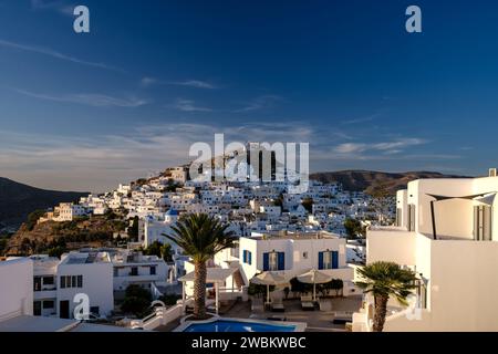 IOS, Griechenland - 14. September 2023 : Blick auf ein malerisches Hotel mit Swimmingpool und das weiß getünchte Dorf iOS Griechenland im Hintergrund Stockfoto