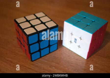 Zwei rubiks Würfel auf einem Schreibtisch mit roten weißen und blauen Seiten Stockfoto