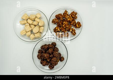 Drei Teller voller Sesam Ladoo, Til Ko Laddu, Jaggery Peanuts Laddoo für Maghe Sankranti und Makar Sankranti Festival in Nepal und Indien Stockfoto