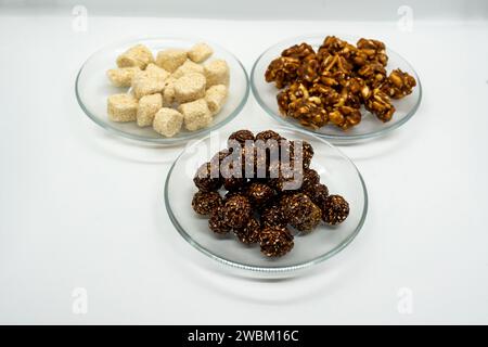 Drei Teller voller Sesam Ladoo, Til Ko Laddu, Jaggery Peanuts Laddoo für Maghe Sankranti und Makar Sankranti Festival in Nepal und Indien Stockfoto