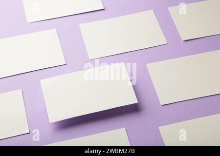 Mockup horizontaler Visitenkartenstapel in Reihen auf violettem texturiertem Papierhintergrund. Stockfoto