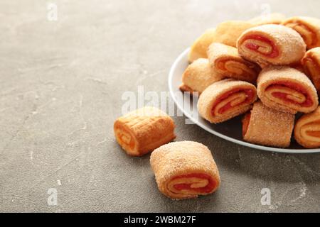 Hausgemachte Kekse, Mini-Brötchen mit Aprikosenmarmelade in Teller auf grauem Hintergrund. Draufsicht. Stockfoto