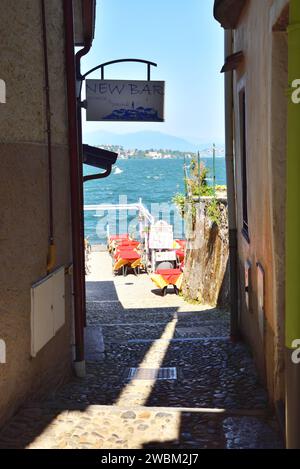 Eine enge Gasse führt zu einem Restaurant am See auf der Isola dei Pescatori am Lago Maggiore, Italien. Stockfoto