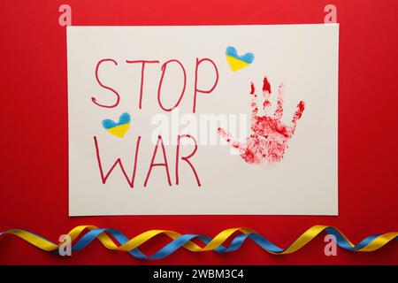 Inschrift Stop war mit Baby Handabdruck auf rotem Hintergrund, Konflikt zwischen der Ukraine und Russland. Kein Krieg, stoppt den Krieg, die russische Aggression. Ukrainische Patri Stockfoto