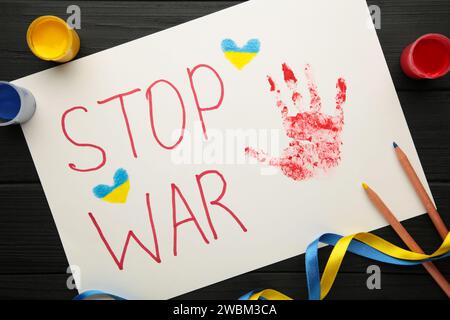 Inschrift Stop war mit Baby Handabdruck auf schwarzem Hintergrund, Konflikt zwischen der Ukraine und Russland. Kein Krieg, stoppt den Krieg, die russische Aggression. Ukrainisches Pat Stockfoto