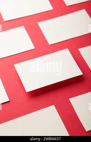 Mockup horizontaler Visitenkartenstapel in Reihen auf rotem Papierhintergrund. Draufsicht Stockfoto