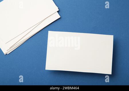 Leere weiße Visitenkarten auf blauem Papierhintergrund. Mockup für Markenidentität. Vorlage für Portfolios von Grafikdesignern. Stockfoto