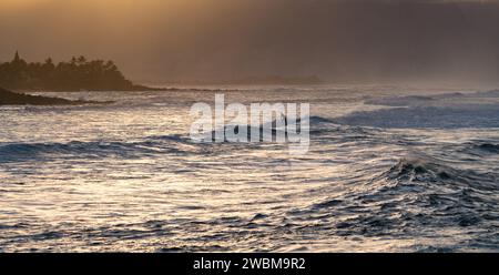 Die Wellen des Ho'okipa Beach leuchten unter der untergehenden Sonne und bieten einen friedlichen Abschluss eines Tages in Mauis Surfparadies. Stockfoto