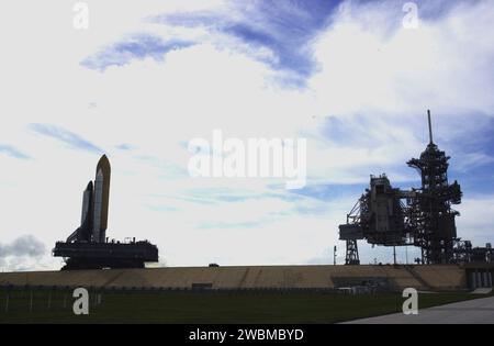 RAUMFAHRTZENTRUM KENNEDY, FLA. -- seine immense Größe, die den Van vor ihm winkt, Space Shuttle Atlantis Zentimeter in Richtung Startplatz. Rechts sind sowohl die drehbare Wartungsstruktur (offen) als auch die feste Wartungsstruktur, die den 80-Fuß-Blitzmast oben hält, zu sehen. Das Shuttle befindet sich auf der Plattform des mobilen Startgeräts, die auf dem Raupentransporter aufliegt. Atlantis ist für den Start am 4. April auf der Mission STS-110 geplant, die den S0-Traverse installieren wird, der die Energie- und Kühlsysteme, die für zukünftige internationale Forschungslabors benötigt werden, am nächsten Tag abhalten wird Stockfoto