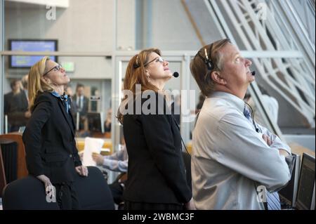 CAPE CANAVERAL, Fla. -- im Schießraum 4 des Startkontrollzentrums im Kennedy Space Center der NASA in Florida, ist Stephanie Stilson, Discovery Flow Director der NASA, links. STS-133 Assistant Shuttle Launch Director und Lead NASA Test Director Charlie Blackwell-Thompson und Shuttle Launch Director Mike Leinbach beobachten, wie das Space Shuttle Discovery eine Spur aus Rauch und Dampf auf der STS-133-Mission zur Internationalen Raumstation in Richtung Orbit sprengt. Der Discovery und seine sechsköpfige Crew sind auf der Mission, das permanente Mehrzweckmodul mit Vorräten und wichtigen Ersatzteilen, A, bereitzustellen Stockfoto