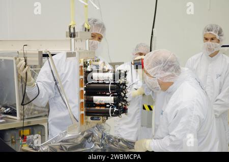 Ball Aerospace-Techniker untersuchen die Flugbatterie des Flyby-Raumfahrzeugs Deep Impact bei Astrotech Space Operations. Das Raumschiff ist dreiachsig stabilisiert, nutzt ein feststehendes Solar-Array und eine NiH2-Batterie und wird den Kometen Tempel 1 während einer NASA-Discovery-Mission sondieren und Aufprallbilder über eine Hochleistungs-Antenne übertragen. Der Start erfolgt an Bord einer Boeing-Delta-II-Rakete vom Launch-Komplex 17-B in Cape Canaveral. Stockfoto