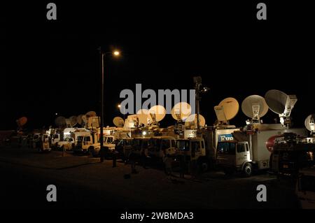 Satelliten-Trucks warten auf Space Shuttle Discovery an der Shuttle Landing Facility Runway 33; Discovery kehrt von der STS-114-Mission zurück, mit ISS-Nachschub, Inspektion, Reparatur und drei Raumwanderungen; Landung auf Edwards AFB verschoben. Stockfoto