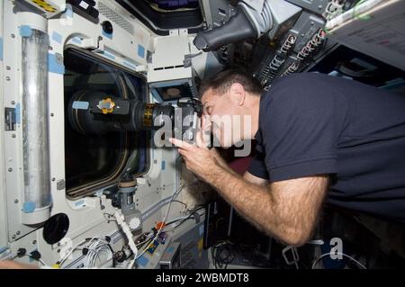 S125-E-011919 (19. Mai 2009) --- Astronaut John Grunsfeld, Missionsspezialist STS-125, benutzt eine Standkamera an einem Fenster über dem Achterdeck des erdumlaufenden Space Shuttle Atlantis, um das Hubble Weltraumteleskop nach seiner Freigabe aus Atlantis zu fotografieren? Roboterarm des Remote Manipulator Systems (RMS). Stockfoto