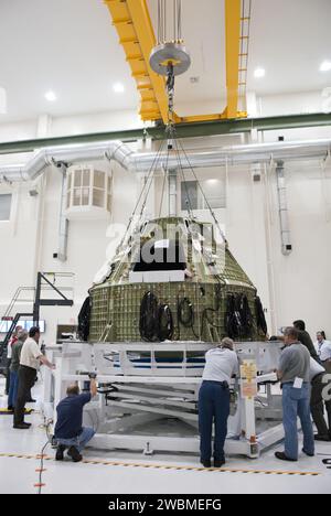 CAPE CANAVERAL, Fla. – Techniker bereiten sich darauf vor, eine spezielle Vorrichtung um eine Orion-Kapsel in der hohen Bucht des Operations & Checkout Building im Kennedy Space Center der NASA in Florida anzubringen. Die Vorrichtung ist so konzipiert, dass sie eine präzise Vorabverarbeitung des Orion-Raumschiffs ermöglicht. Eine Orion-Kapsel wird für einen Flugtest 2014 auf einer Mission vorbereitet, die keine Astronauten transportieren wird. Foto von Tim Jacobs Stockfoto