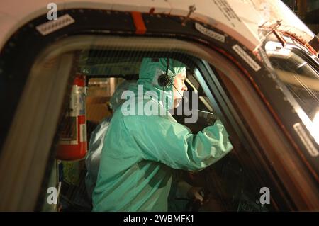 In der Orbiter Processing Facility des Kennedy Space Centers inspizierte der STS-114 Pilot James Kelly das Cockpitfenster der Space Shuttle Discovery während der Besatzungsausrüstung Interface Tests. Die Mission „Return to Flight“ STS-114 wird ein Ersatz-Kontrollmoment-Gyroskop und das Mehrzweck-Logistikmodul Raffaello mit Vorräten für die Internationale Raumstation tragen. Das Startfenster erstreckt sich vom 12. Mai bis zum 3. Juni. Stockfoto