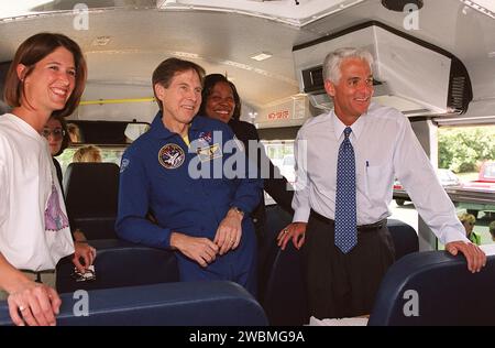 RAUMFAHRTZENTRUM KENNEDY, FLA. -- der Bildungskommissar Charlie Crist (rechts) spricht mit Schülern der Ronald McNair Magnet School, Cocoa, Florida, im Schulbus, der sie zum KSC brachte, um das Space Shuttle Endeavour auf Mission STS-100 zu starten. Crist feierte den 20. Jahrestag des Space Shuttle-Programms mit seinem Besuch beim KSC für den Start. In Uniform (Mitte) ist der Astronaut Sam Durrance, der auch die Schüler begleitete. Die Schülerinnen und Schüler werden von der Lehrerin Nicole Waxberg betreut (links). Stockfoto