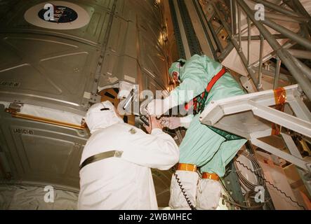 RAUMFAHRTZENTRUM KENNEDY, FLA. -- Techniker im Payload Changeout Room arbeiten daran, das U.S. Lab Destiny in der Nutzladerampe des Orbiters zu sichern. Die PCR ist der umschlossene, umweltgeregelte Teil der rotierenden Wartungsstruktur, der die Nutzlastabgabe am Startplatz und die vertikale Installation im Nutzlastbereich des Orbiters unterstützt. Destiny, ein Schlüsselelement beim Bau der Internationalen Raumstation, ist 28 Fuß lang und wiegt 16 Tonnen. Dieses Forschungs- und Kontrollzentrum ist das ausgeklügelteste und vielseitigste Weltraumlabor, das jemals gebaut wurde. Es werden letztendlich insgesamt 2 enthalten Stockfoto