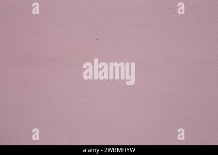Alte abblätternde Farbe an der Wand. Hintergrund aus violettem Stuck. Stockfoto