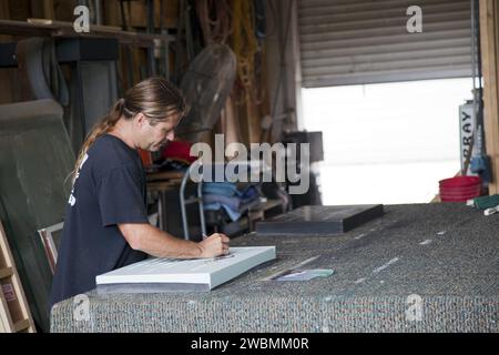 CAPE CANAVERAL, Fla. – Bei C Spray Glass Blasting in Cocoa Beach, Florida, vervollständigt ein Arbeiter die Gedenktafel, um den Radstopp des Space Shuttle Atlantis zu markieren. Die spezielle Gedenktafel wird dauerhaft an der Shuttle Landing Facility (SLF) am Rand der Landebahn im Kennedy Space Center der NASA in Florida angebracht, um die letzte Landung des Space Shuttle zu feiern. Atlantis beendete die STS-135-Mission, indem er am 21. Juli 2011 um 5:57 Uhr EDT bei der SLF landete. Atlantis flog 33 Missionen, absolvierte 4.848 Umlaufbahnen der Erde, reiste fast 126 Millionen Meilen und verbrachte 307 Tage im Weltraum. Atlantis trug 2 Stockfoto