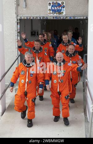 CAPE CANAVERAL, Fla. -- die sechs STS-134-Astronauten des Space Shuttle Endeavour, in ihren orangen Start- und Einstiegsanzügen, winken den Medien und anderen Zuschauern zu, während sie in Richtung des Astrovan gehen, der vor dem Operations- und Checkout-Gebäude im Kennedy Space Center der NASA in Florida parkt. Das modifizierte Airstream-Freizeitfahrzeug transportiert seit 1984 Astronauten zu ihrem Raumschiff. Der Weg ist Commander Mark Kelly, rechts, und Pilot Greg H. Johnson. Hinter Kelly stehen die Crewkollegen Michael Fincke und Andrew Feustel. Hinter Johnson stehen Crewkollegen Roberto Vittori mit der European Sp Stockfoto