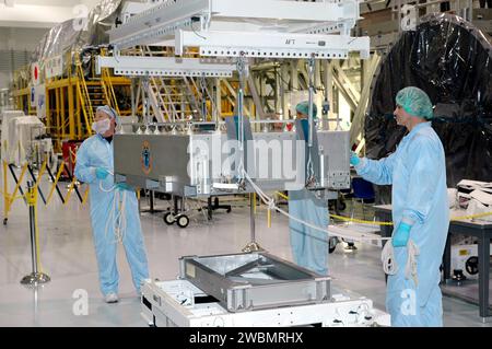 RAUMFAHRTZENTRUM KENNEDY, FLA. - Techniker in der Verarbeitungsanlage der Raumstation bereiten die DTO-Box (Thermal Protection System Detailed Test Objective) vor, die auf den Lightweight Multi-Purpose Experiment Support Structure Carrier (LMC) gehoben werden soll. Es wird auf dem leichten Mehrzweck-Experiment Support Structure Carrier (LMC) platziert, um mit dem Space Shuttle Discovery für die Mission STS-114 zu fliegen. Das DTO enthält Fliesenproben, mit denen Astronauten neue Reparaturtechniken für das Wärmeschutzsystem auf der Umlaufbahn testen können. Das Startfenster für die Mission STS-114 ist vom 12. Mai bis 3. Juni. Stockfoto