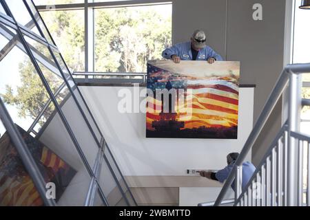 In der Lobby im zweiten Stock der Propellants North Facility der NASA, einem mit Platin bewerteten LEED Net-Zero-Gebäude, in dem Verwaltungsbüros und ein Kryobrennstoffladen untergebracht sind, installieren die Arbeiter Kunstwerke im Stil eines Shuttle-Themas. Stockfoto