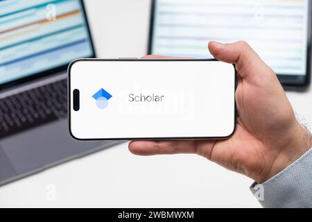 PRAG, TSCHECHIEN - NOVEMBER 2023: Google Scholar wird auf dem iPhone-Bildschirm angezeigt, während ein Mann das moderne Smartphone hält Stockfoto