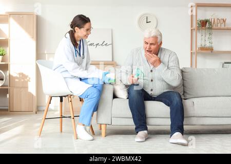 Seniorin mit Vernebler und Krankenschwester zu Hause Stockfoto