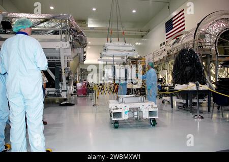 RAUMFAHRTZENTRUM KENNEDY, FLA. - Die Techniker der Raumstation-Verarbeitungsanlage beobachten sorgfältig, wie ein Kran die DTO-Box (Thermal Protection System Detailed Test Objective) hebt. Es wird auf dem leichten Mehrzweck-Experiment Support Structure Carrier (LMC) platziert, um mit dem Space Shuttle Discovery für die Mission STS-114 zu fliegen. Das DTO enthält Fliesenproben, mit denen Astronauten neue Reparaturtechniken für das Wärmeschutzsystem auf der Umlaufbahn testen können. Das Startfenster für die Mission STS-114 ist vom 12. Mai bis 3. Juni. Stockfoto