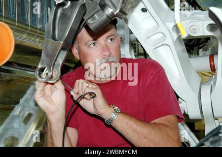 Der leitende Inspektor Scott Minnick inspiziert den Montagebereich der Rückzugsglieder am rechten Hauptfahrwerk von Atlantis in der Orbiter Processing Facility Bay 1 im Kennedy Space Center. Letzte Woche wurde ein kleiner Riss gefunden. Atlantis ist für die STS-121-Rückflug-Mission im September 2005 geplant. Stockfoto