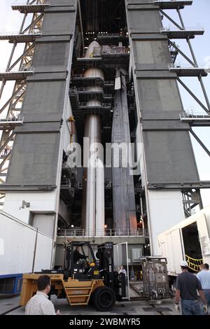 CAPE CANAVERAL, Fla. -- im Hintergrund von der Atlas-V-Rakete, die in der Vertical Integration Facility am Space Launch Complex 41 steht, wird der Radioisotope-thermoelektrische Generator (MMRTG) für die Mission Mars Science Laboratory (MSL) der NASA, eingeschlossen in einem Gittercontainer namens "Gorilla Cage", aus seinem Anhänger entfernt. Der Generator wird an die Spitze der Rakete angehoben und auf dem MSL-Raumschiff installiert, das in der Nutzlastverkleidung eingekapselt ist. Die MMRTG wird die Energie erzeugen, die für die Mission benötigt wird, aus dem natürlichen Zerfall von Plutonium-238, einer nicht waffenfähigen Form von Stockfoto