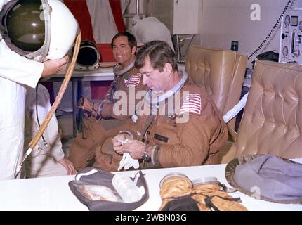 RAUMFAHRTZENTRUM KENNEDY, FLA. - Techniker unterstützen die Astronauten John Young (rechts) und Bob Crippen (links) bei Anzugsoperationen im Mannschaftsquartier des Operations and Checkout Building ein paar Stunden vor dem geplanten Start des Space Shuttles auf seinem Erstflug. Stockfoto