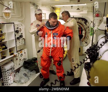 Vor dem Eintritt in das Space Shuttle Discovery erhält STS-102 Pilot James Kelly Hilfe bei seinem Start- und Einstiegsanzug von Technikern im Weißen Raum. Die Mission ist Kellys erster Shuttle-Flug. Discovery trägt das Multifunktions-Logistikmodul Leonardo auf dem achten Bauflug zur Internationalen Raumstation. Leonardo wird als primäres Liefersystem für die Nachlieferung und Rückgabe von Fracht an der Station, die unter Druck steht, bis zu 10 Tonnen Laborgestelle liefern, die mit Geräten, Experimenten und Vorräten für die Ausstattung des neu installierten U.S. Laboratory Destiny gefüllt sind. Scheibe Stockfoto