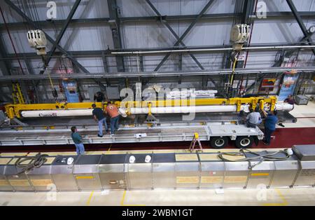 CAPE CANAVERAL, Fla. – Innerhalb der Orbiter Processing Facility-2 im Kennedy Space Center der NASA in Florida helfen Techniker dabei, wie ein großer Kran den Roboterarm des Space Shuttle Atlantis mit dem Remote Manipulator System (RMS) auf eine spezielle Trägerplattform senkt. Das RMS wird zum Johnson Space Center der NASA in Houston transportiert, wo es für zukünftige Raumflüge genutzt werden kann. Die Arbeit ist Teil der Übergangs- und Pensionierung des Shuttles Atlantis. Das Shuttle wird für die Ausstellung im Kennedy Space Center Visitor Complex vorbereitet. Stockfoto