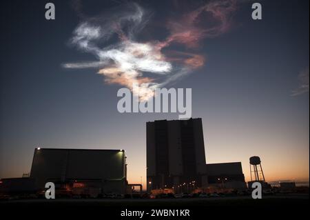 CAPE CANAVERAL, Fla. - Wispy-Kondensstreifen vom Start des Space Shuttle Discovery auf der STS-131-Mission schweben über dem Vehicle Assembly Building im Kennedy Space Center der NASA in Florida. Shuttle Discovery startete am 5. April 2010 um 621 Uhr EDT. Die siebenköpfige STS-131-Besatzung wird das Mehrzweck-Logistikmodul Leonardo liefern, gefüllt mit Vorräten, einem neuen Schlafplatz und wissenschaftlichen Racks, die in die Labore der Internationalen Raumstation überführt werden. Die Besatzung wird auch ein Gyroskop am Stationsfachwerk ausschalten, einen Ersatz-Ammoniaktank installieren und wieder einrasten Stockfoto