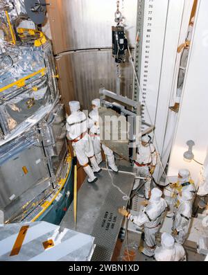 RAUMFAHRTZENTRUM KENNEDY, FLA. -- Techniker im Nutzlast-Umschaltraum am Startplatz 39B entfernen die Batterien vom Hubble-Weltraumteleskop zum Aufladen. Die beiden sechs Batteriesätze werden für 130 Stunden zum Batterielabor im Fahrzeugmontagegebäude gebracht und anschließend wieder in das Teleskop eingesetzt. Das Aufladen wurde notwendig, als der erste Startversuch der Space Shuttle Mission STS-31 am 10. April geschrubbt wurde. Ein zweiter Versuch ist für den 24. April um 31 Uhr EDT geplant. Stockfoto