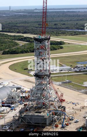 CAPE CANAVERAL, Fla. – Im Kennedy Space Center der NASA in Florida zeigt diese aus der Vogelperspektive des Parkgeländes nördlich des 525 Meter hohen Vehicle Assembly Building einen neuen mobilen Trägerraketen für das im Bau befindliche Constellation Program. Im Hintergrund befinden sich der Atlantische Ozean und der Launch Complex 41 auf der Cape Canaveral Air Force Station oben links, von dem aus Atlas-V-Raketen gestartet werden. Nach Fertigstellung ist der Turm etwa 345 Meter hoch und verfügt über mehrere Plattformen für den Zugang von Mitarbeitern. Die Basis ist leichter als die mobile Trägerplatte des Space Shuttle Stockfoto