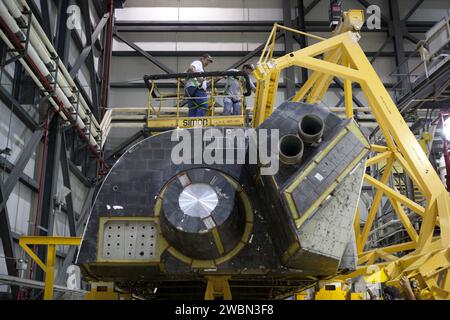 CAPE CANAVERAL, Fla. – Innerhalb der Orbiter Processing Facility-1 im Kennedy Space Center der NASA in Florida überwachen Techniker der United Launch Alliance den Fortschritt, während ein großer Kran das rechte Orbitalmanövriersystem oder OMS zur Installation auf dem Space Shuttle Atlantis bewegt. Dies ist das letzte Mal, dass ein OMS-Pod auf Atlantis installiert wird. Das OMS lieferte dem Shuttle einen Schub für die Orbiteinlage, den Treffpunkt und den Deorbit und konnte bis zu 1.000 Pfund Treibstoff an das hintere Reaktionskontrollsystem liefern. Das OMS ist in zwei unabhängigen Pods untergebracht, die sich auf jeder Seite der hinteren Sicherung des Shuttle befinden Stockfoto