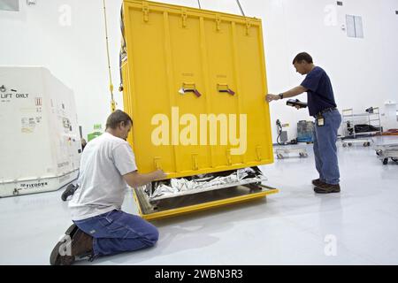 CAPE CANAVERAL, Fla. -- innerhalb der Raumstation-Verarbeitungsanlage im Kennedy Space Center der NASA in Florida senken Techniker die Abdeckung eines Containers ab, der die orbitale Ersatzeinheit für die Hauptbus-Schalteinheit der Raumstation umschließt. Die Einheit ist eine der Nutzlasten, die in Kennedy verarbeitet werden und nach Japan geflogen werden, um die HTV-4-Station zu starten, die derzeit für diesen Sommer geplant ist. Stockfoto